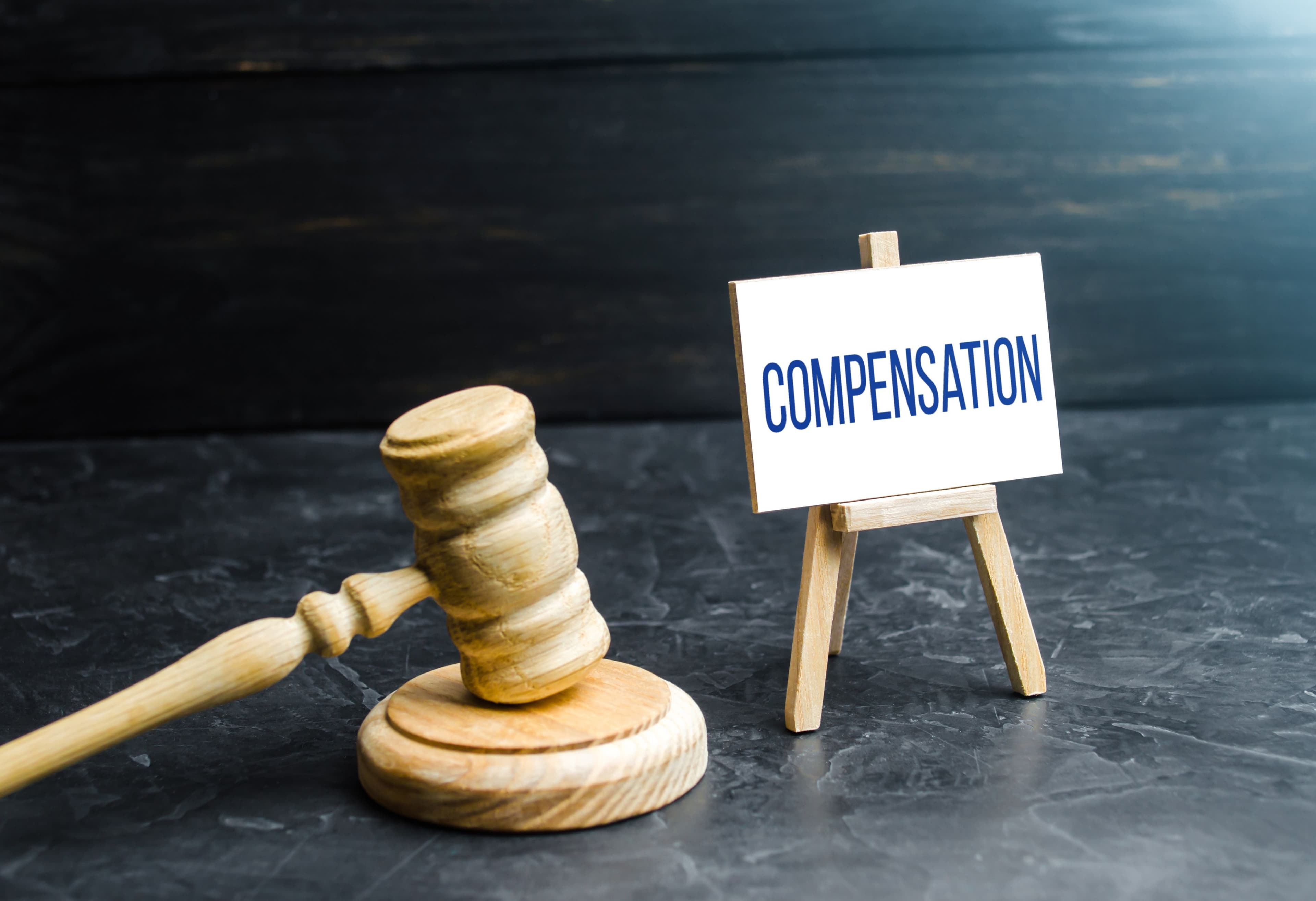 Gavel next to a sign reading "Compensation," symbolizing compensation for personal injury accidents.