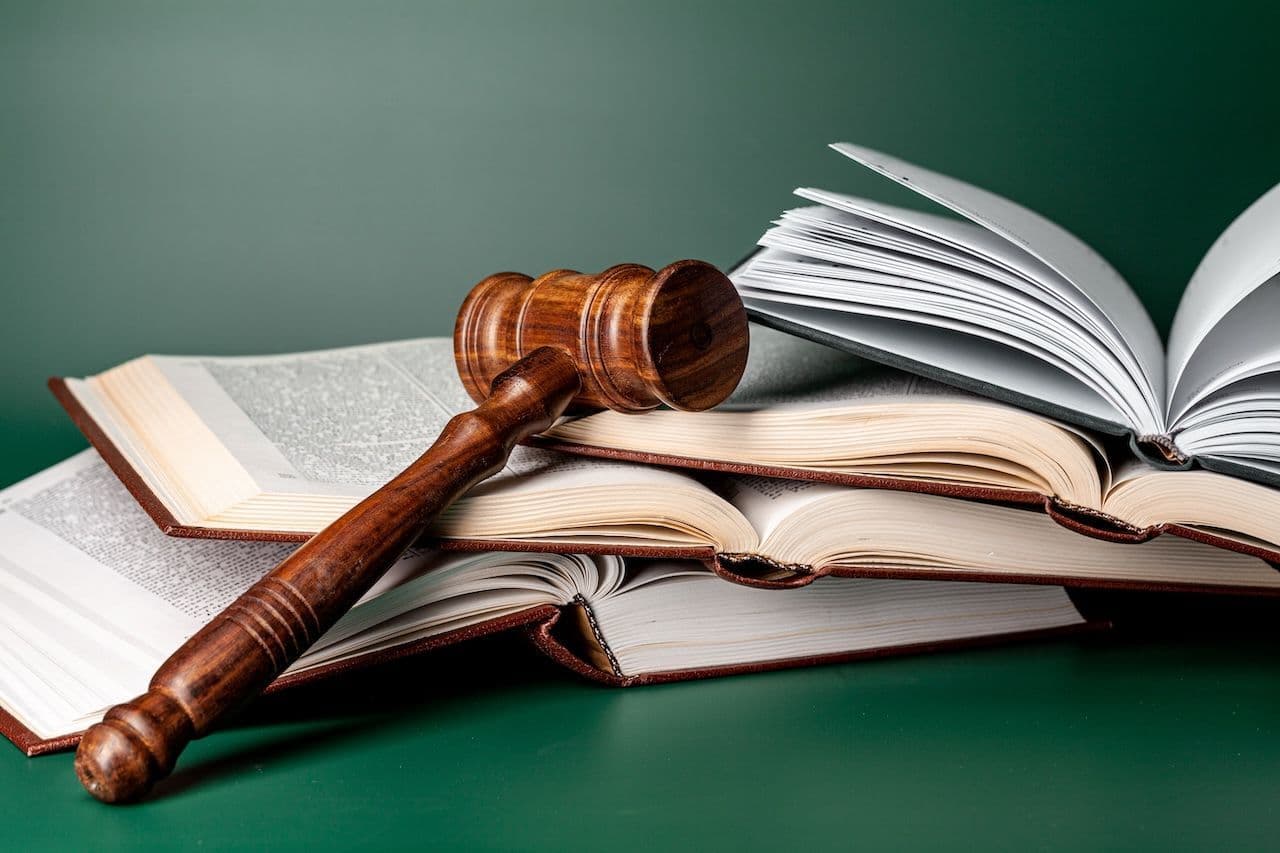 A gavel laid across a stack of open books, indicating the power of words found in a legal terms glossary.