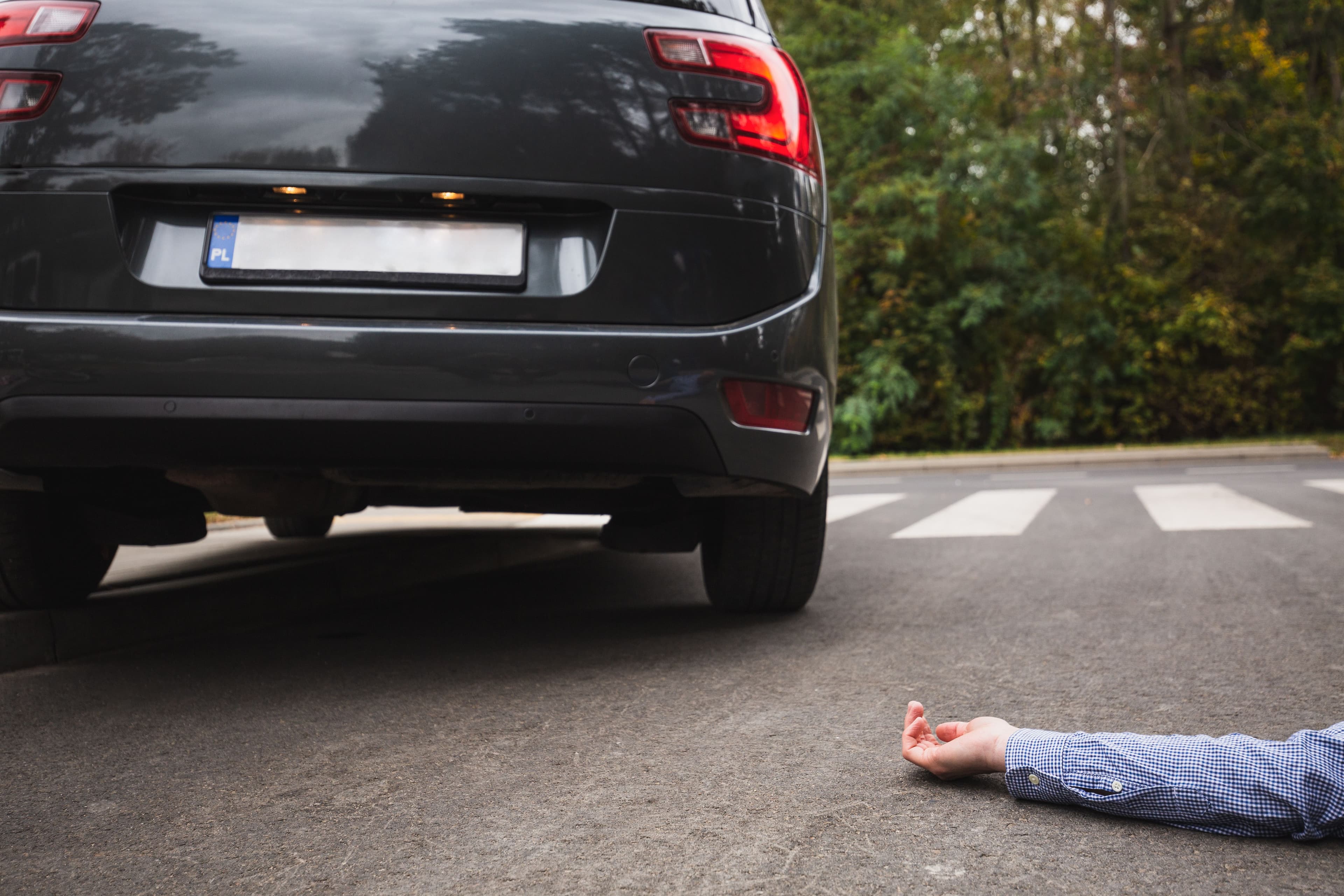 A car driving away from an injured person lying on the ground after an Oregon hit and run.
