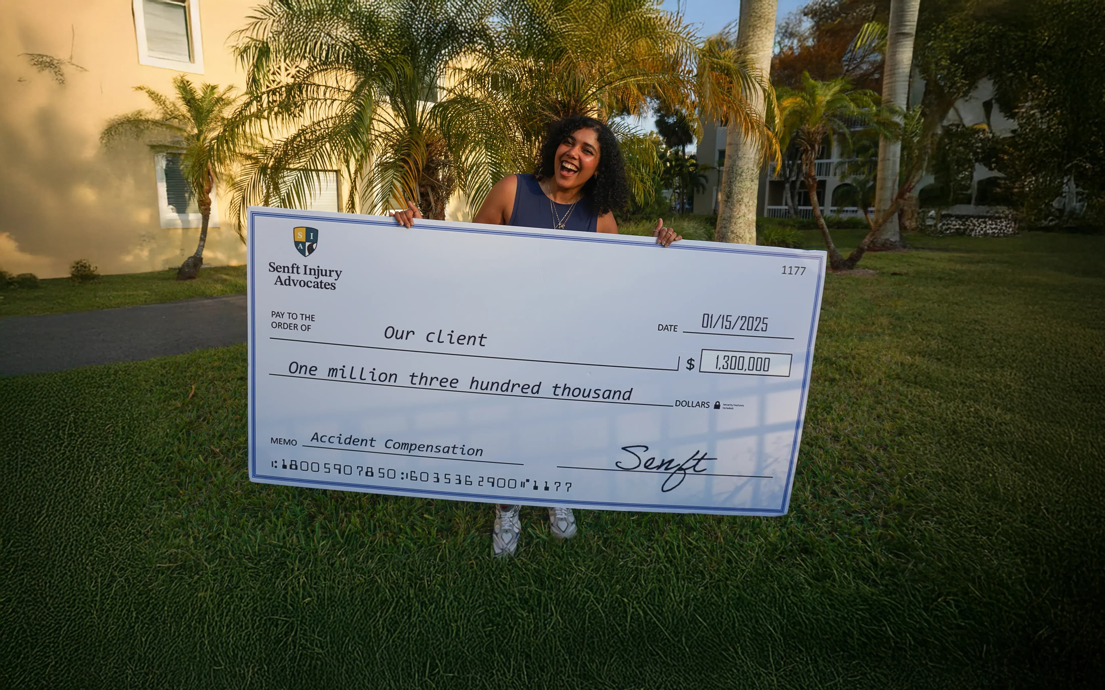 Client holding large check of one million three hundred thousand dollar from her car accident compensation claim